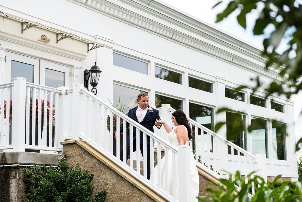groom helping bride up the stairs, outdoor wedding portrait