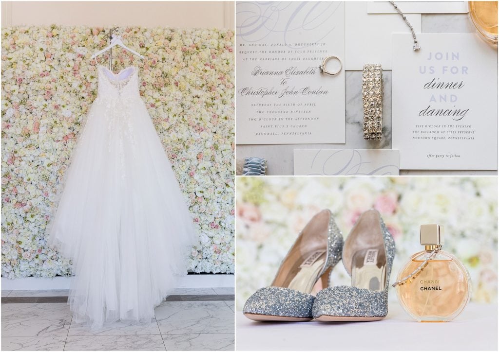 Wedding dress from Pronovias hung on floral wall backdrop and bridal accessories | Ashley Gerrity Photography