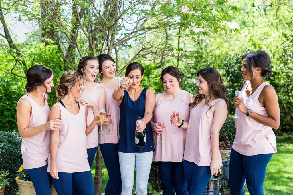 Bride popping some champagne with her bridesmaids | Ashley Gerrity Photography www.ashleygerrityphotography.com