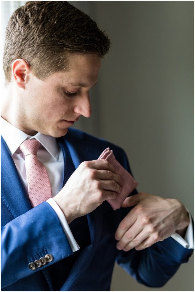 Groom putting the finishing touches to his wedding suit from Suit Supply | Ashley Gerrity Photography www.ashleygerrityphotography.com