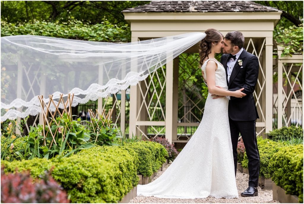 Bride and groom portrait in the 18th Century Gardens in Old City with brides veil blowing in the wind