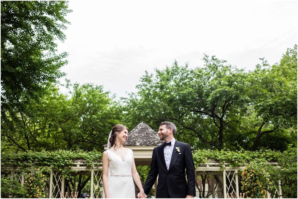 Portrait of bride and groom in garden holding hands