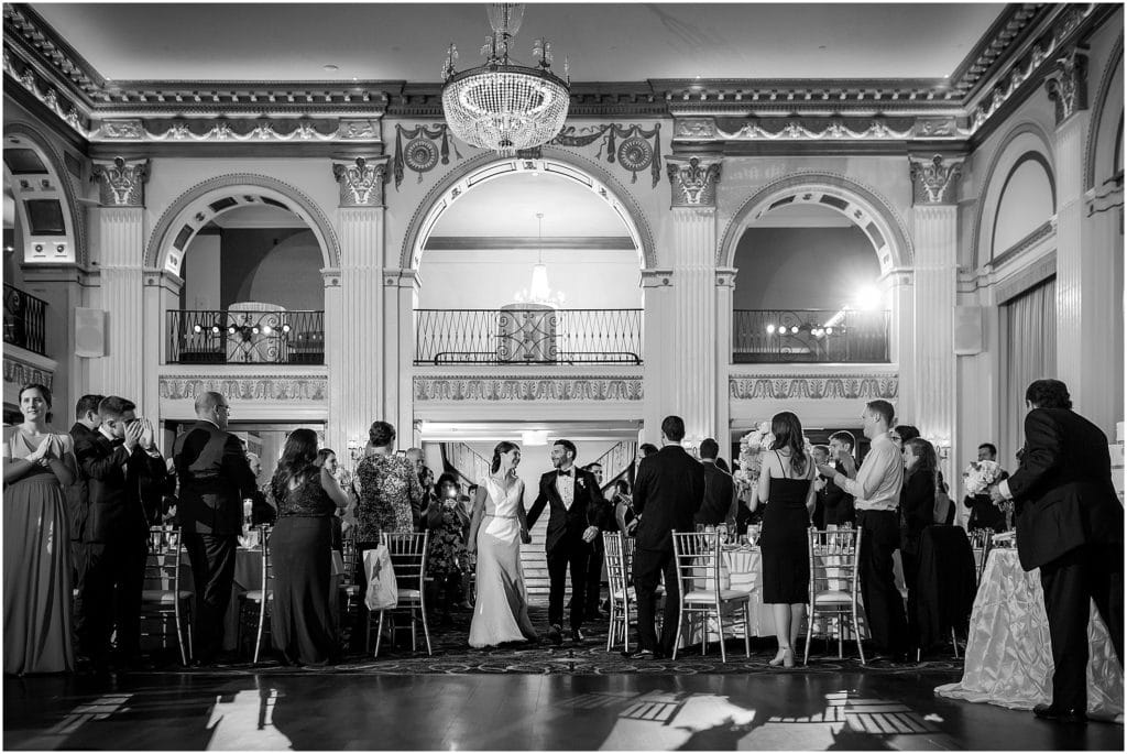 Black and white image of bride and groom entering their wedding reception at the Ben Franklin Ballroom