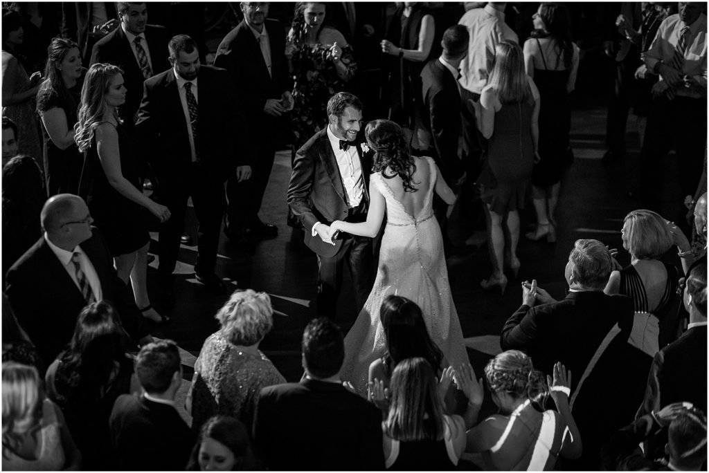 Bride and groom dancing surrounded by their family and friends on the dance floor