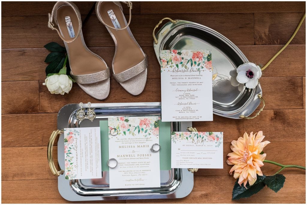 floral wedding invitation flat lay with bridal jewelry and wedding shoes
