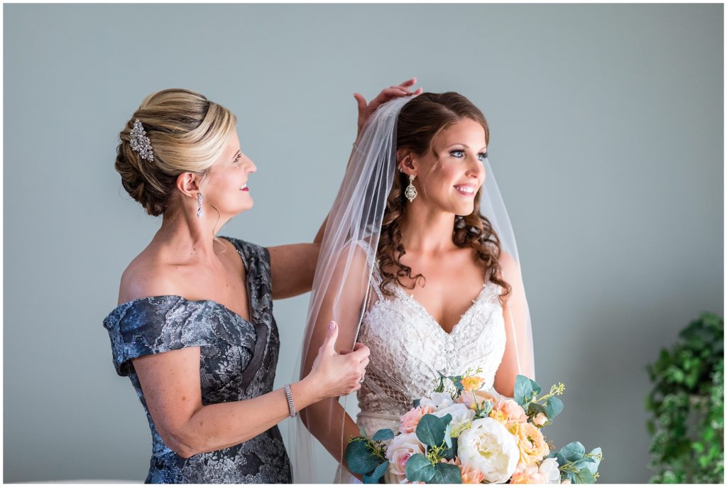 bride with her mother helping with the veil