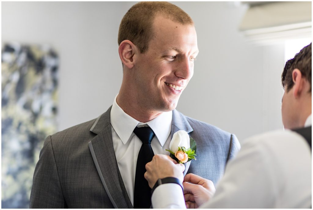 traditional groom portrait getting help with boutonniere