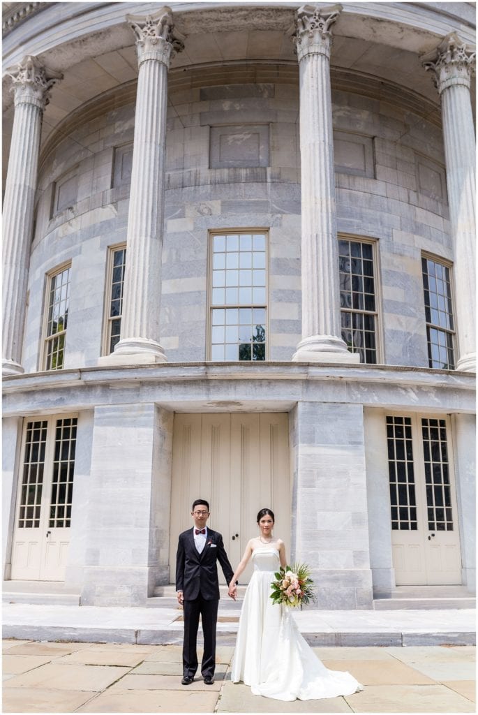 Bride and groom standing outside in front of marble building