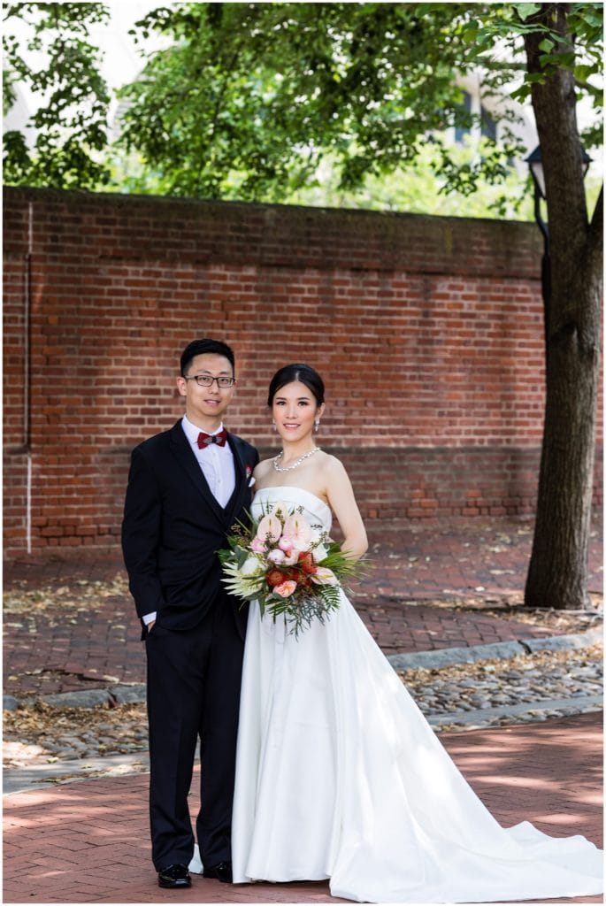 traditional bride and groom portrait in front of brick wall in Old City Philadelphia