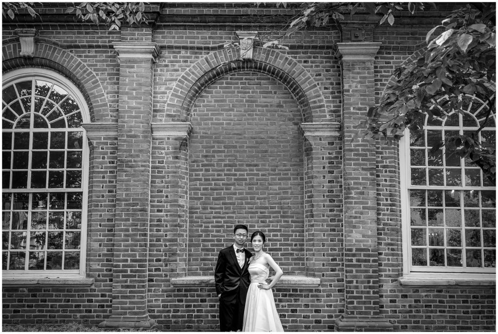 traditional black and white bride and groom portrait in front of brick wall