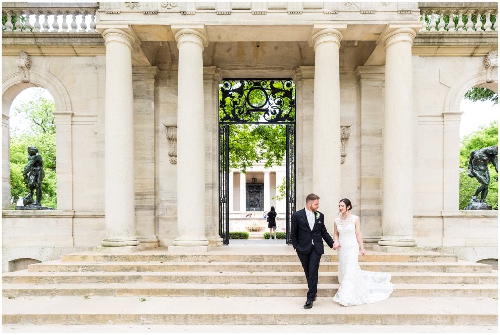 Groom leading bride down the stairs of the Rodin Museum