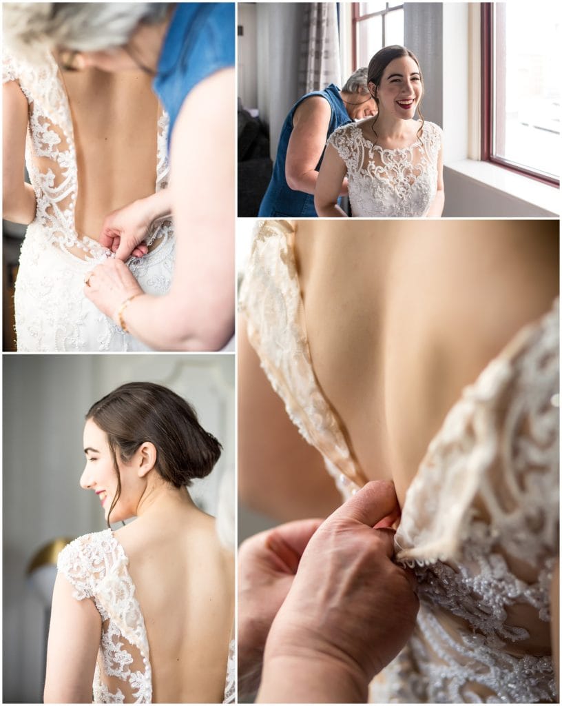 Bride getting buttoned up into her lace Maggie Sottero wedding dress