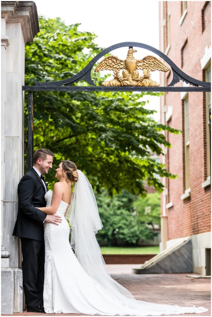 Romantic outdoor portrait of bride and groom under a wrought iron gate