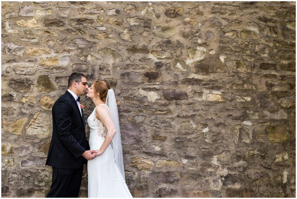 Bride and groom holding hands, about to kiss, romantic outdoor wedding portrait