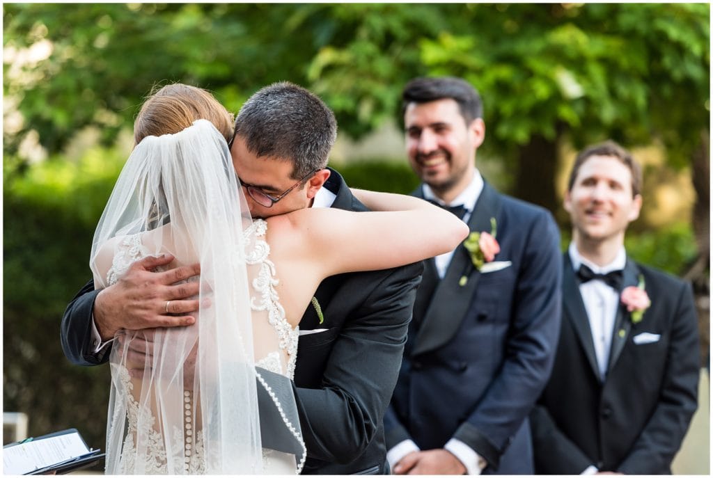 groom hugging his bride during their outdoor wedding ceremony