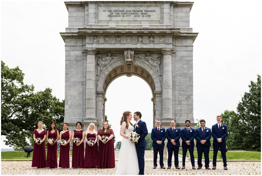 traditional bridal party portrait with maroon and navy color palette at Valley Forge Park Archway