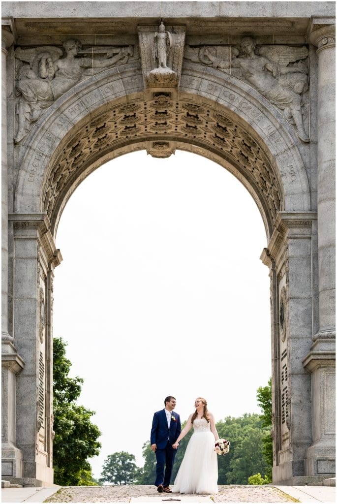 Bride and groom portrait laughing under archway at Valley Forge Park