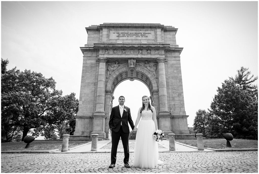 traditional black and white bride and groom portrait under archway in Valley Forge Park
