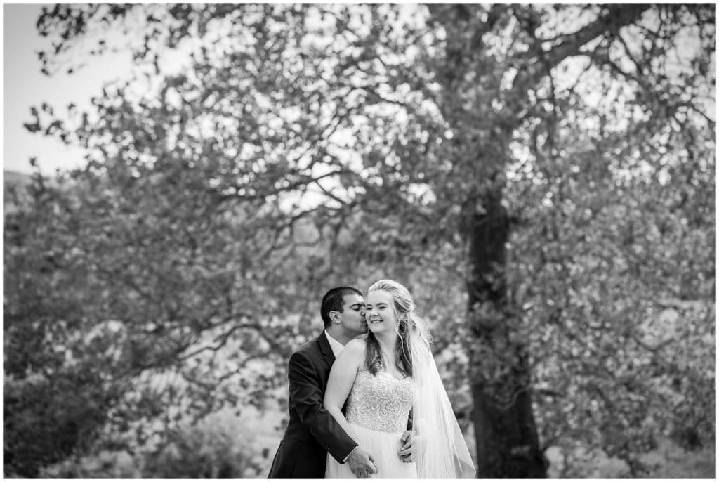 romantic black and white groom kissing bride portrait