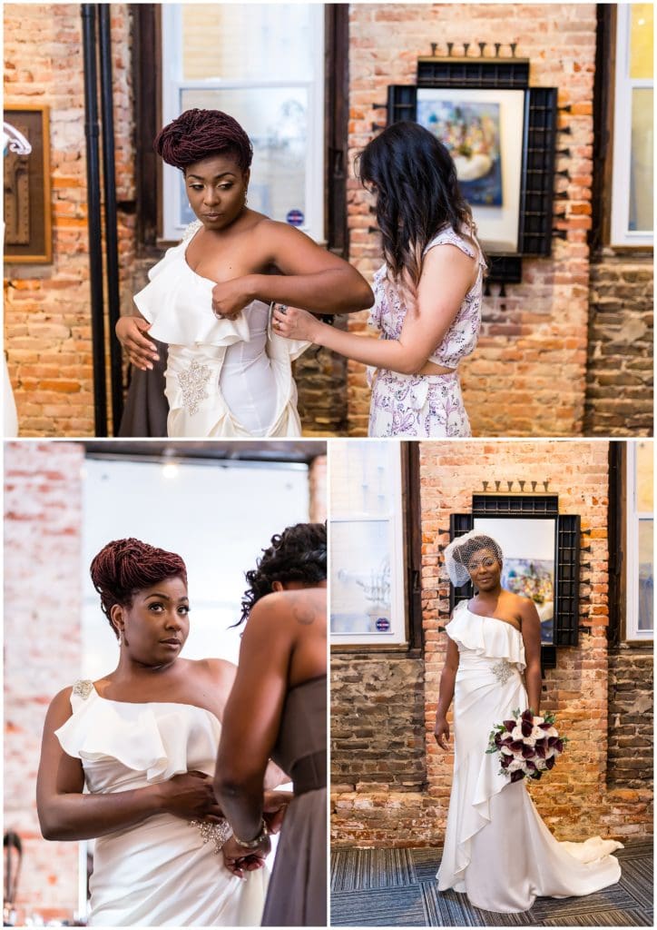 Bridesmaids helping the bride into her wedding gown