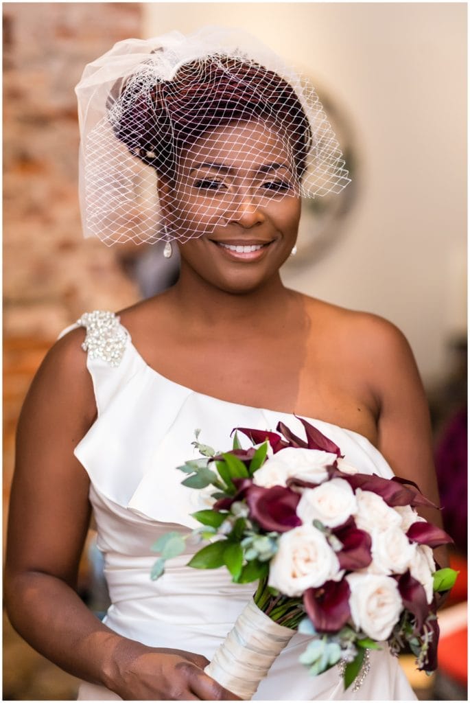 Traditional bridal portrait with maroon bouquet and net veil