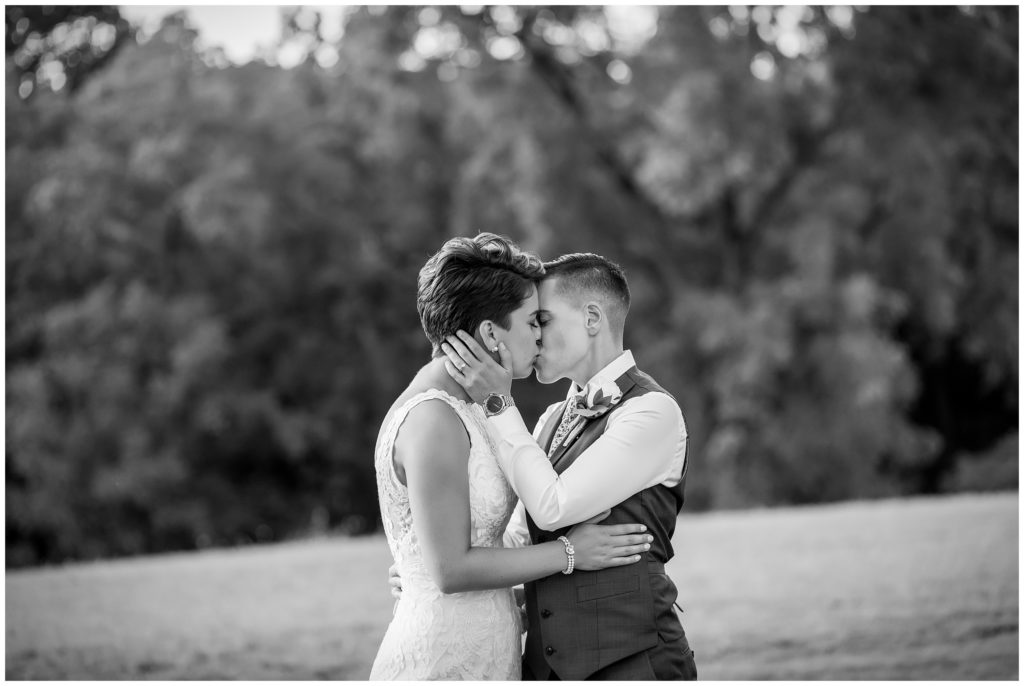 Traditional black and white wedding portrait with LGBT brides kissing
