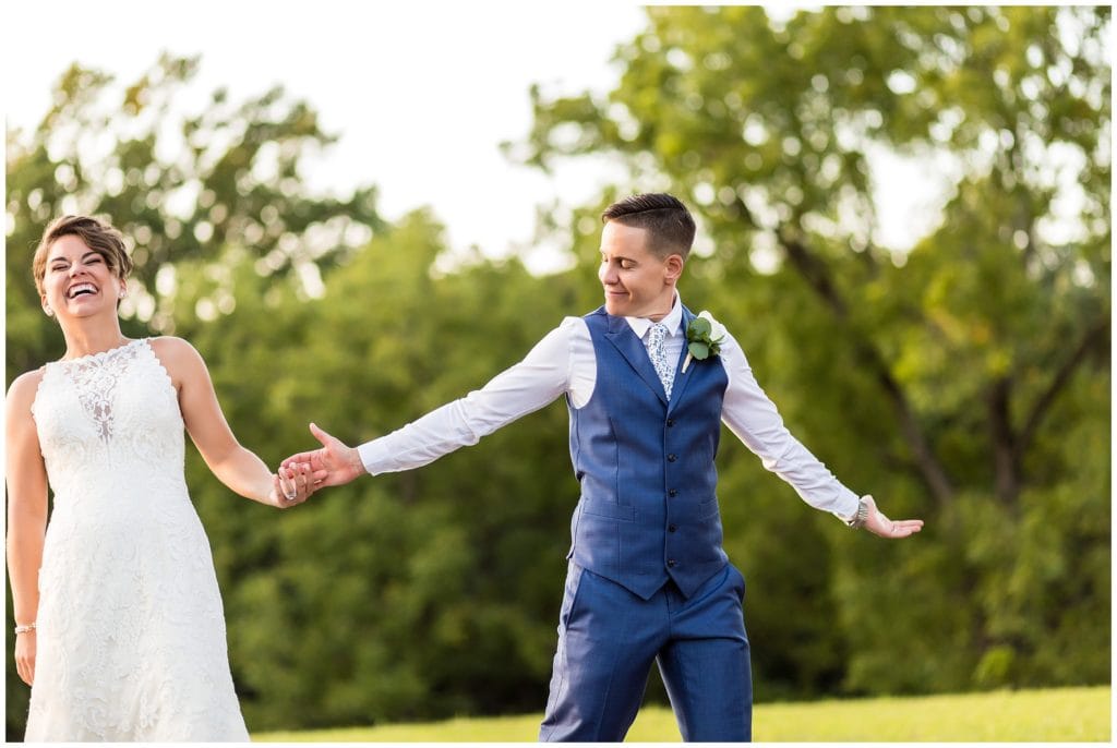 Outdoor wedding portrait with bride showing off her tuxedo