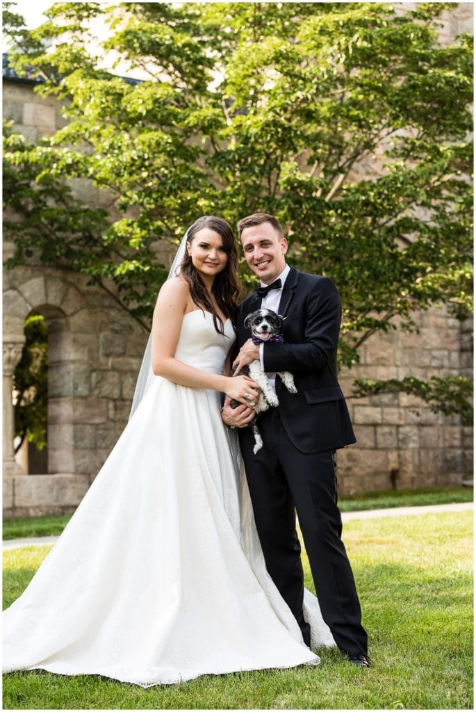 Wedding portrait with bride and groom holding their dog
