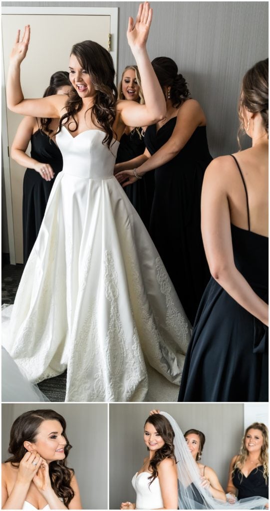 Bridesmaids helping bride into her dress and veil