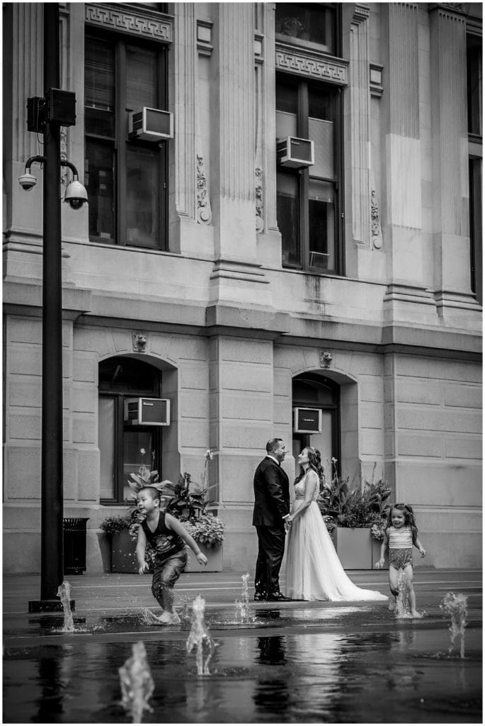 Black and white wedding portrait bride and groom through water fountains at Philadelphia City Hall