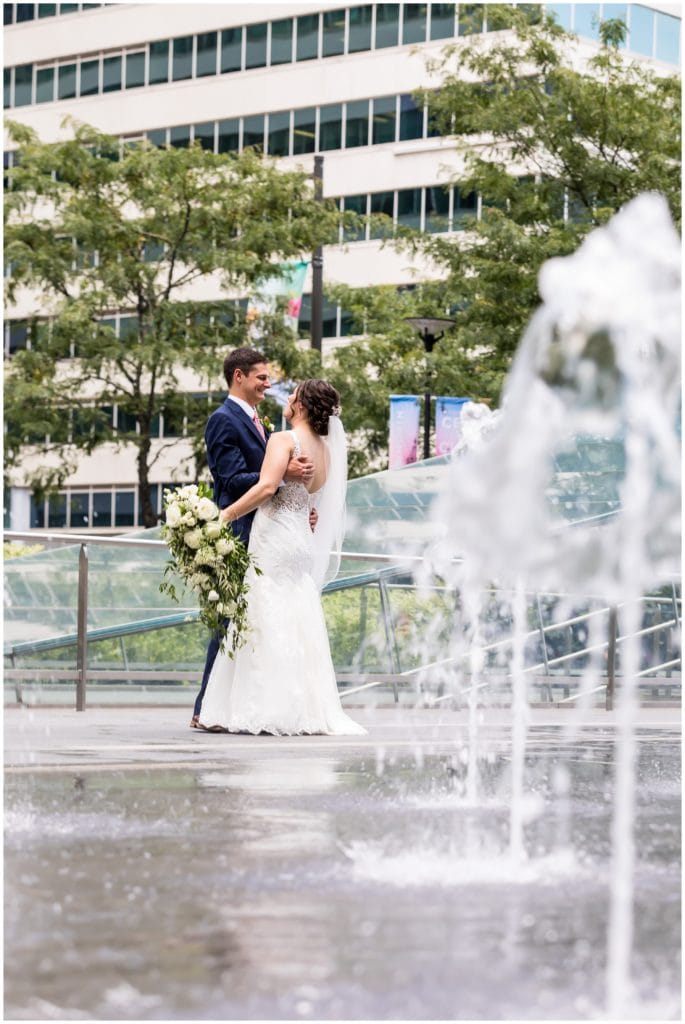 Bride and groom portrait through water fountains at Philadelphia City Hall