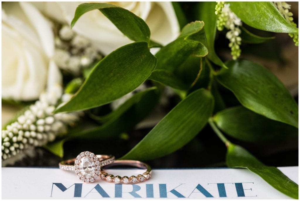 Gold engagement and wedding rings with brides name and bouquet