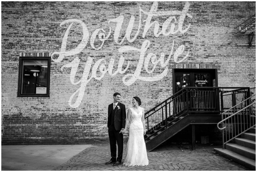 black and white wedding portrait in front of "do what you love" mural in Philadelphia