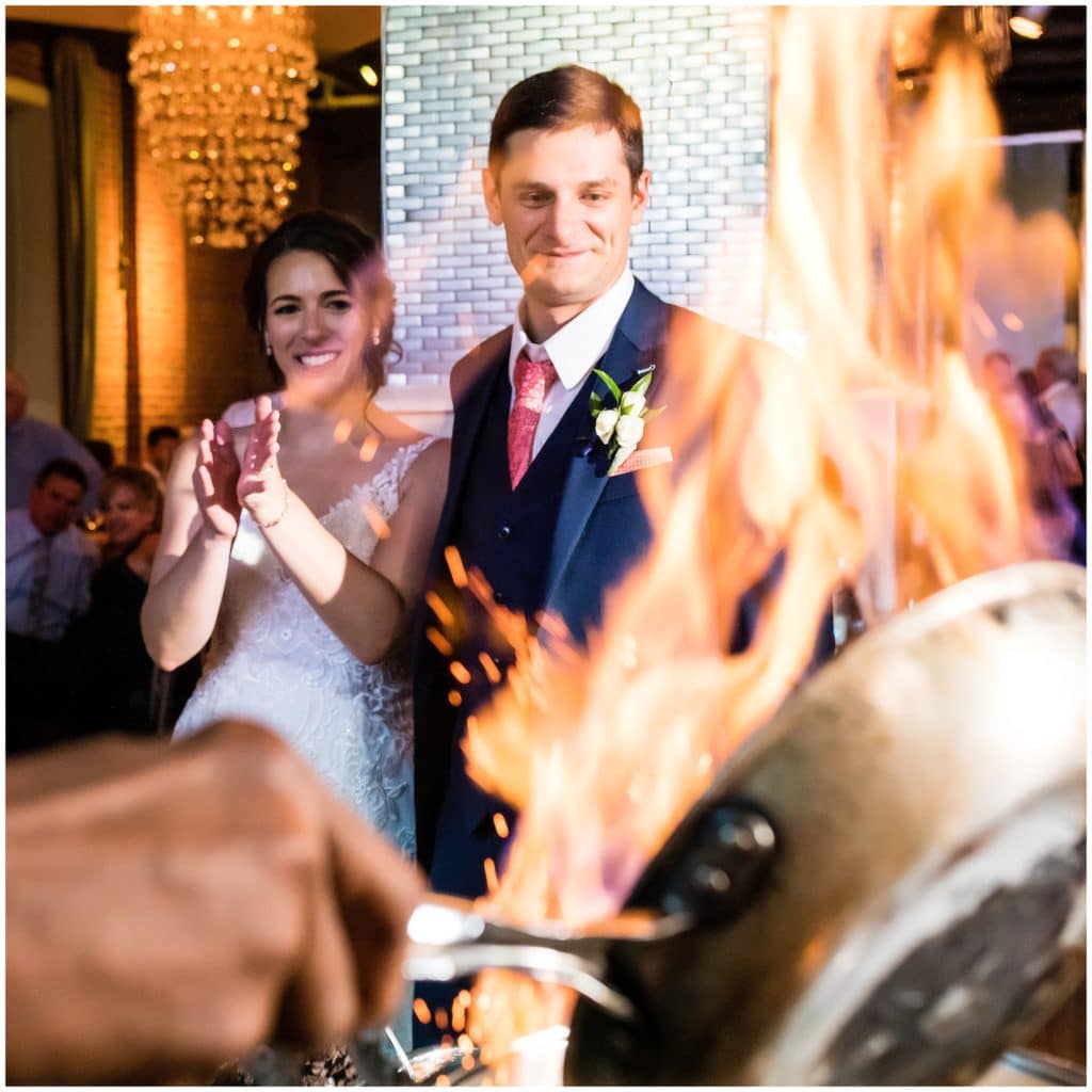 Bride and groom portrait through flames at Cescaphes signature flambé station