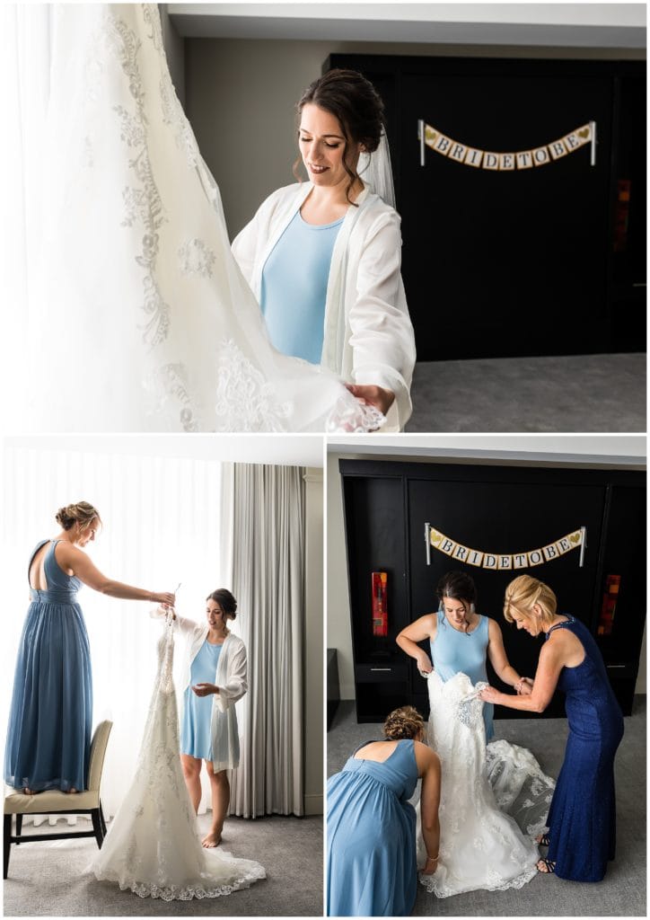 Bride getting into wedding gown with help of her sister and mother