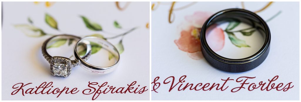 Wedding bands and engagement rings next to bride and grooms names on wedding invitation