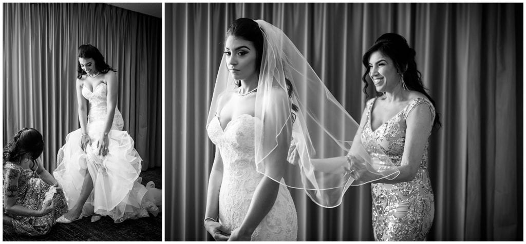 Mother of the bride helping bride put on garter and veil, black and white wedding portraits