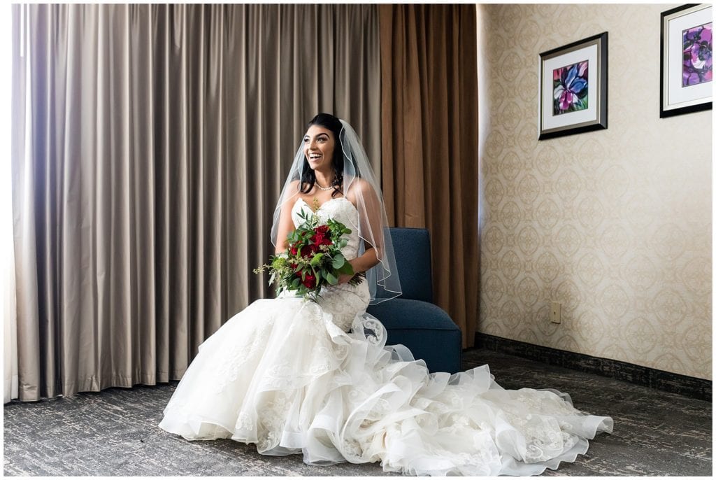 Traditional window lit bridal portrait with red rose bridal bouquet