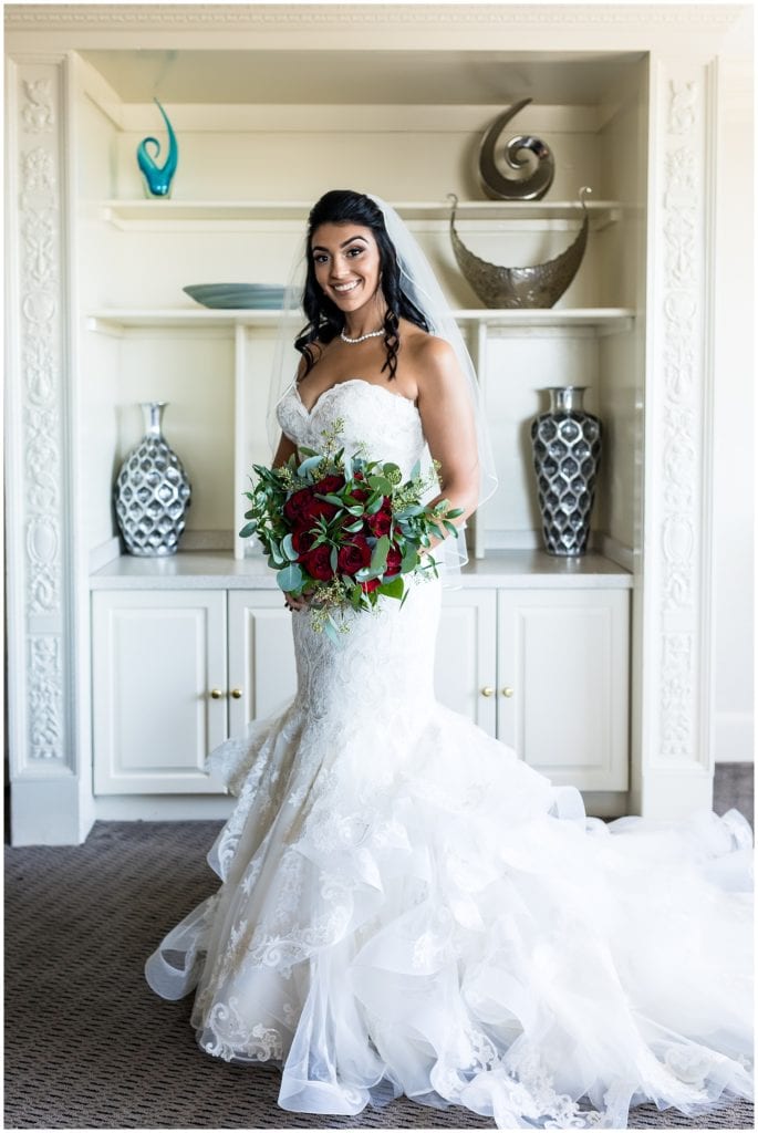 Traditional window lit bridal portrait with red rose bridal bouquet