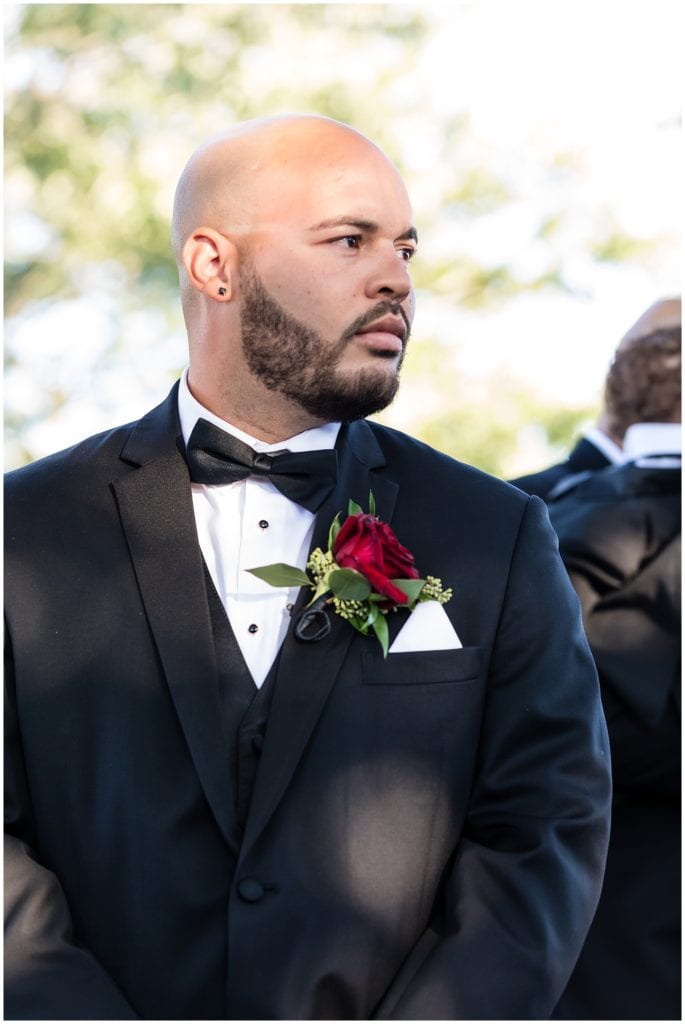 Groom waiting for bride at the end of the aisle
