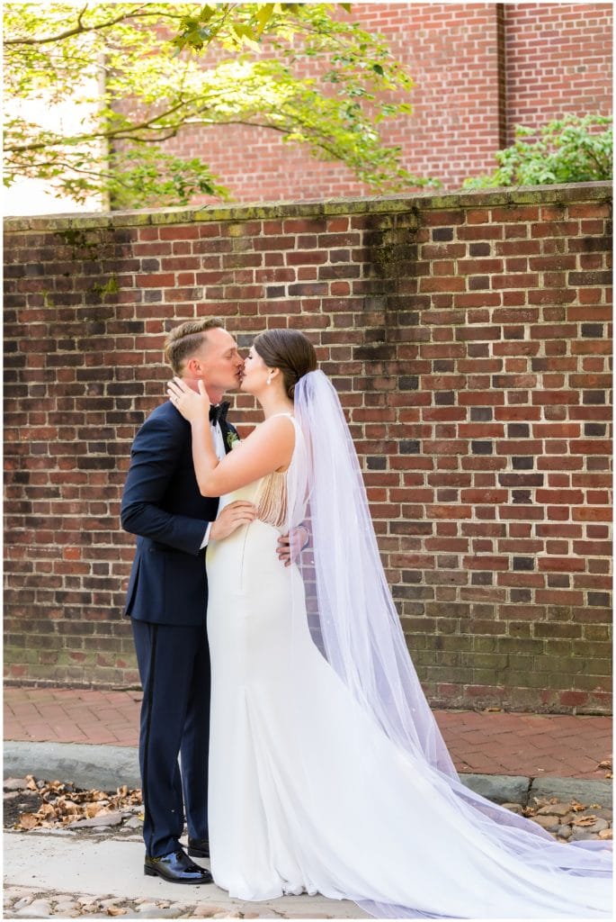 Bride and groom kissing after first look on Old City cobblestone street