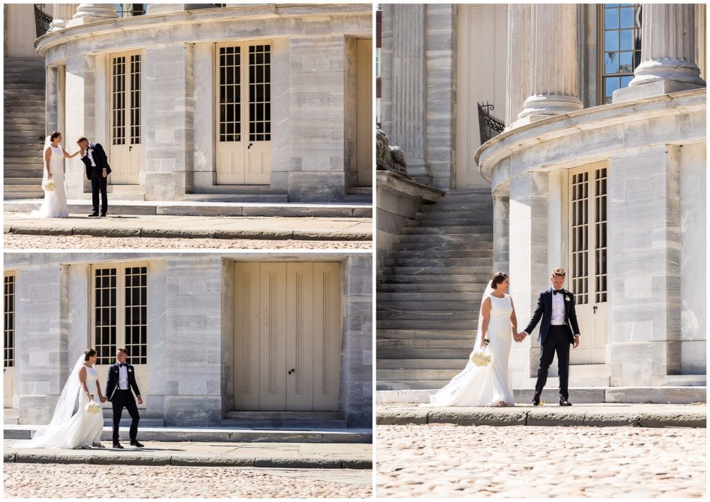 Bride and groom walking and groom kissing brides hand in front of Merchant Exchange building