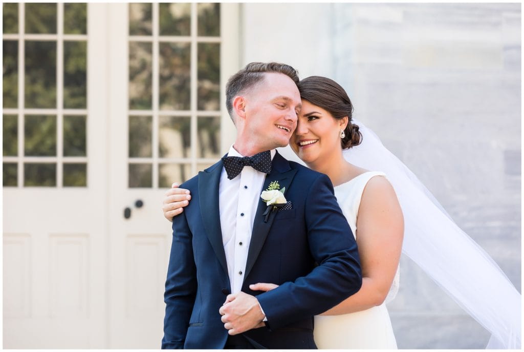 Bride and groom holding each other and laughing portrait