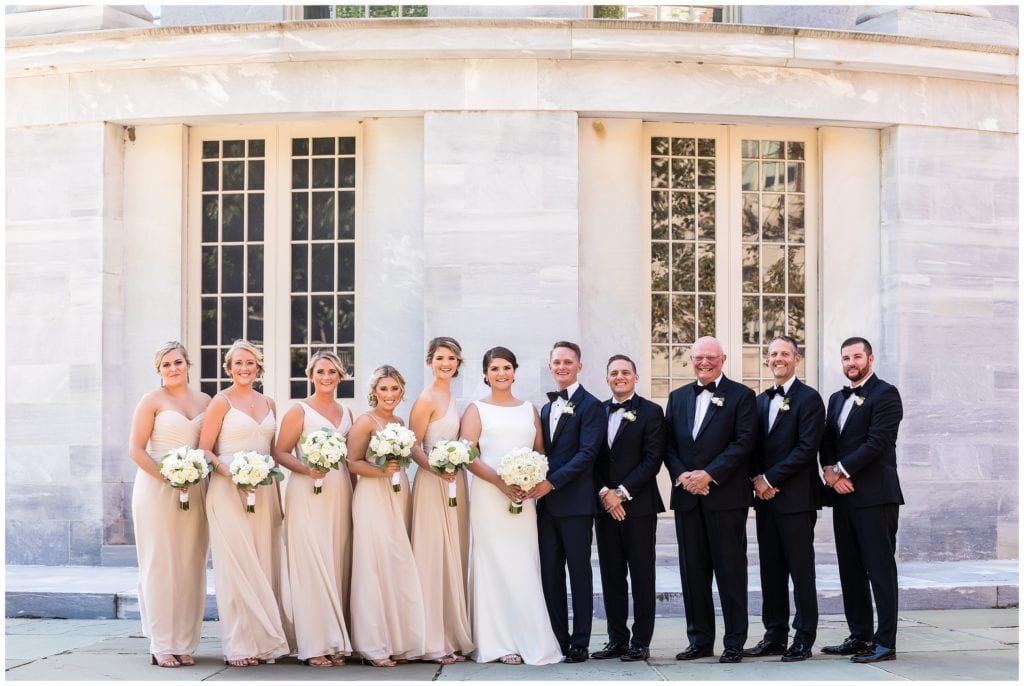 Traditional wedding party portraits with tan bridesmaids dresses and black tuxedos