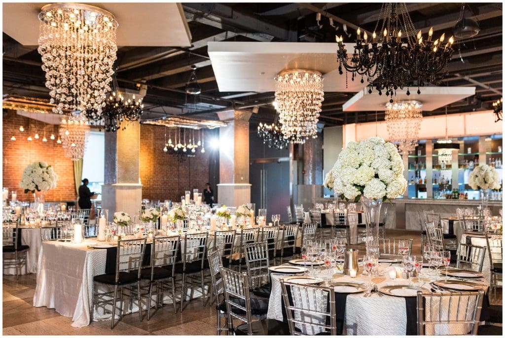 Lavish Tendenza wedding reception setup with large white floral centerpieces
