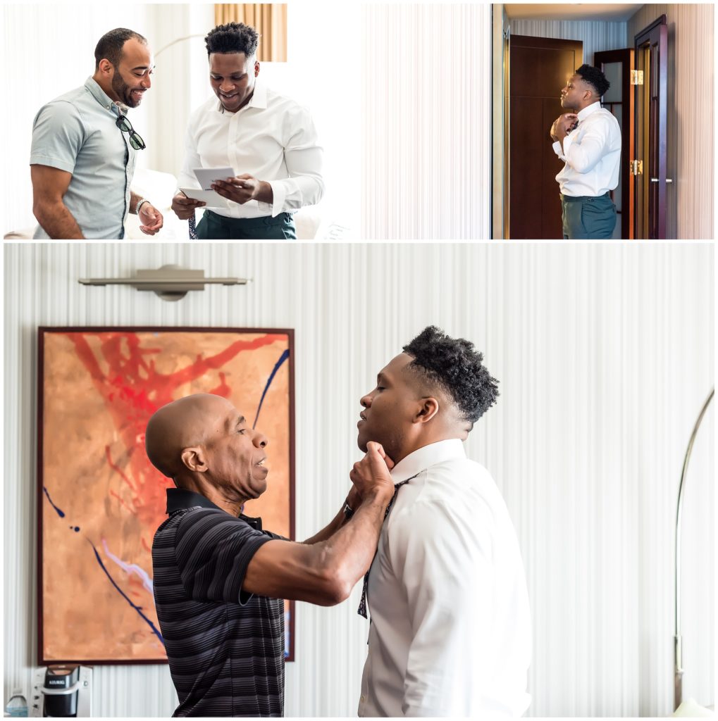 Groom reading letter and getting dressed with his father tying his tie