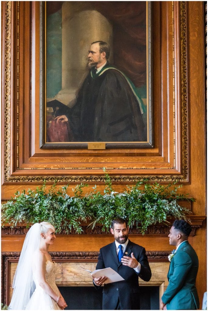 Bride and groom during wedding ceremony in library at College of Physicians