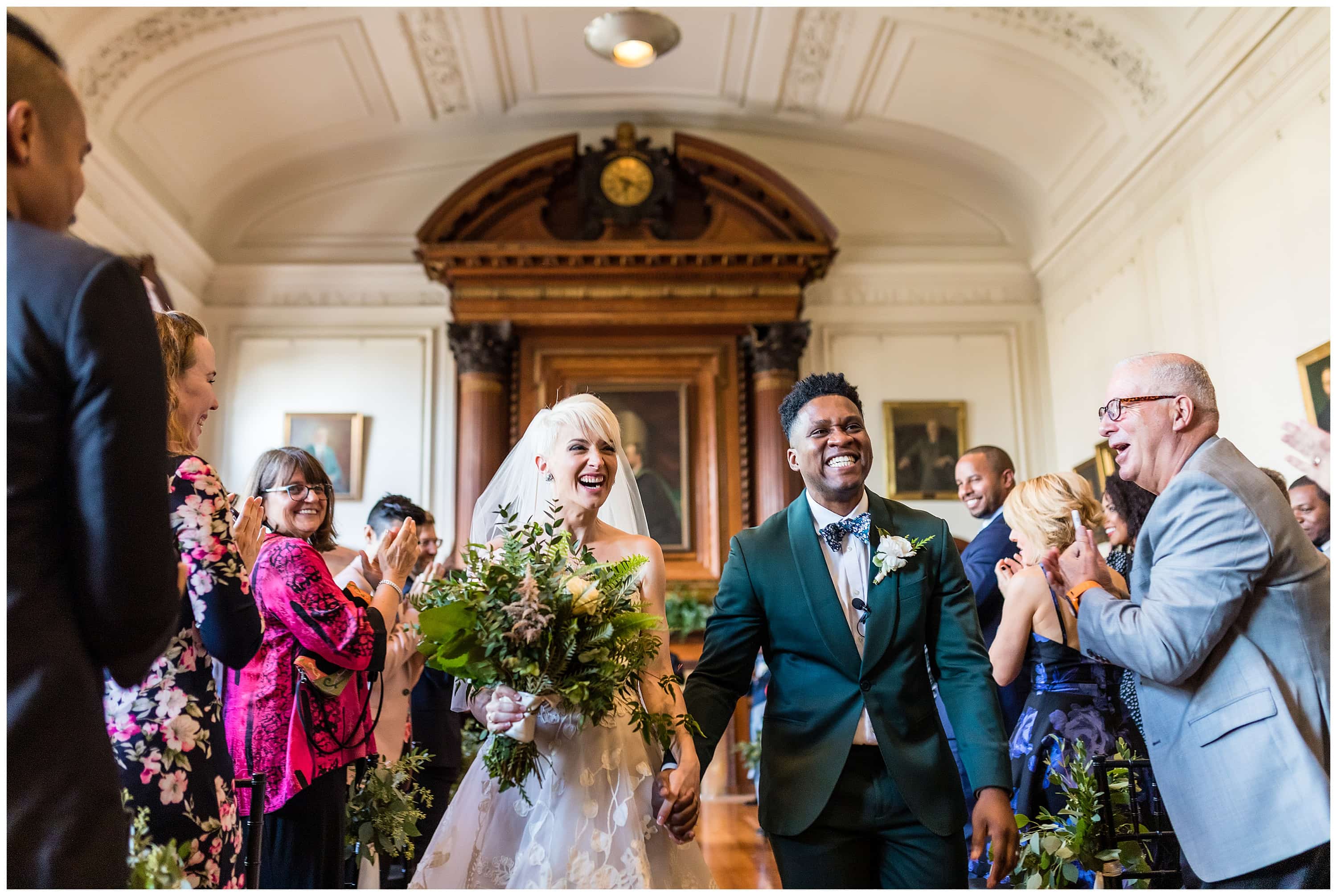 Guests cheer for bride and groom walking up the aisle after wedding ceremony
