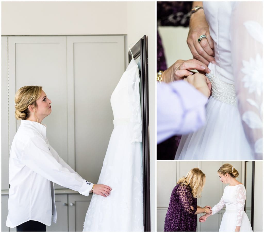 Bride admiring her gown and mother of the bride helping her into her old wedding gown