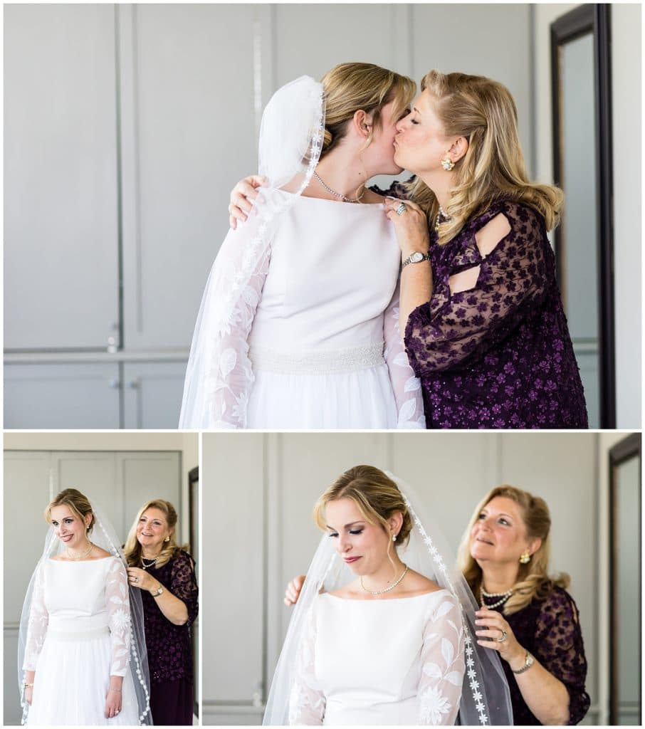 Mother of the bride attaching veil and admiring daughter in her old altered wedding gown